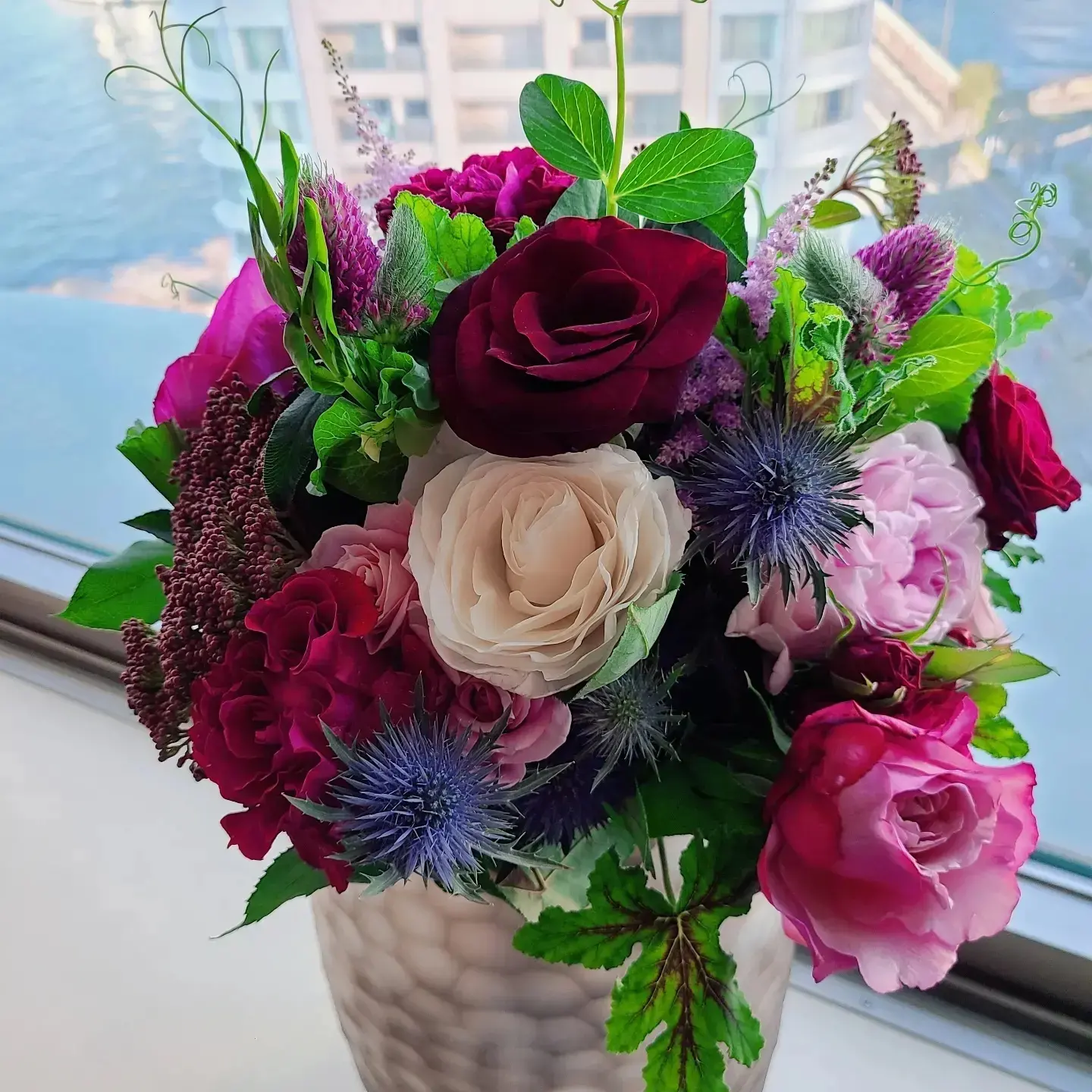 擺放在石台上的白花與綠葉花藝作品